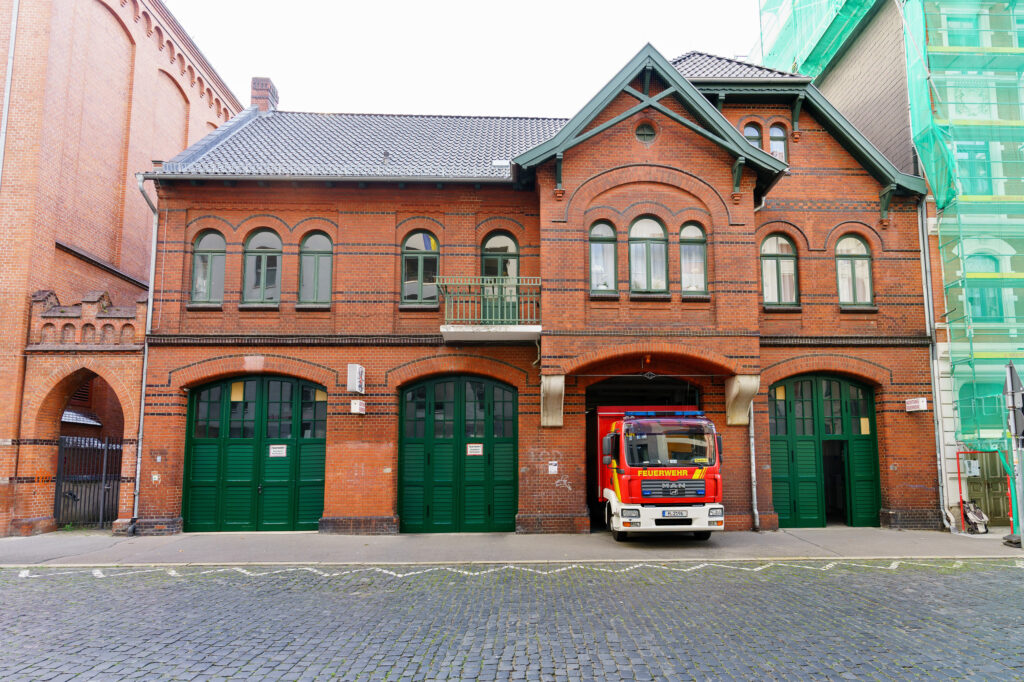 Außenansicht des Gebäudeteils in der Küchengartenstraße mit einem Einsatzfahrzeug in einer der Tore