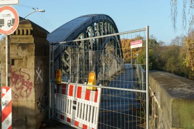 Der Fußweg auf der nördlichen Seite der Kanalbrücke der Wunstorfer Straße ist mit Absperrmaterial und einem bauzan abgesperrt.