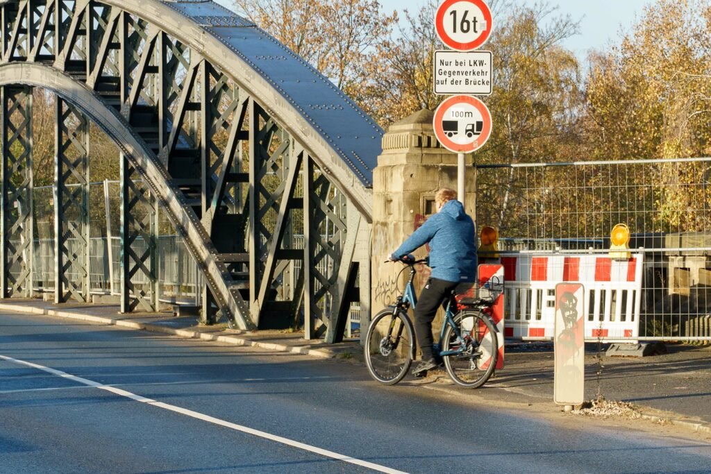 Ein Radfahrer fährt direkt vor der Brücke vom Fußweg auf die Fahrbahn.