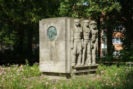 Seite des Johann-Egestorff-Denkmals zeigt Relief mit drei Arbeitern.