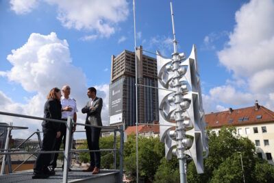 Erster Stadtrat Dr. Axel von der Ohe neben einer modernen Sirene